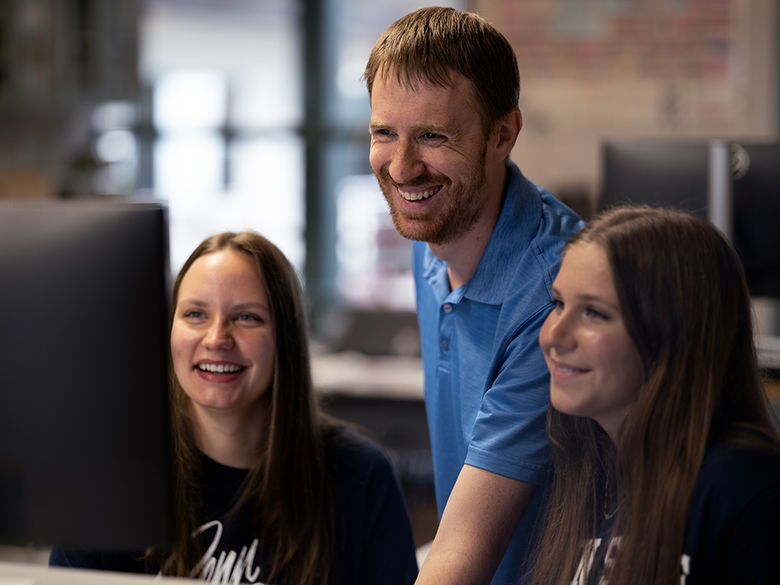 Instructor coaches students working on a project