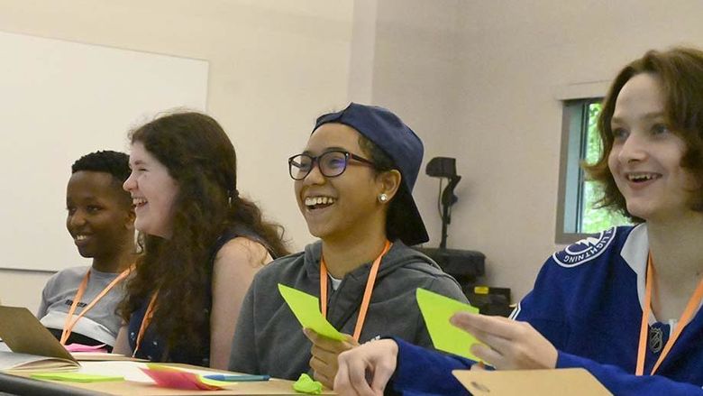 Four students sitting at a table during a class